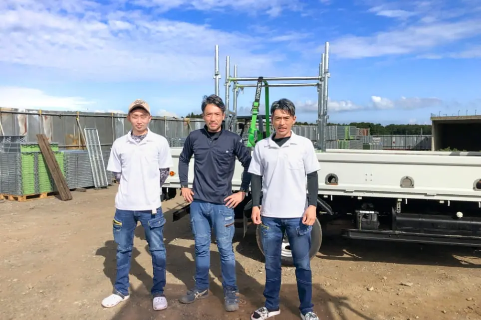 建設現場で3人のスタッフが並ぶ